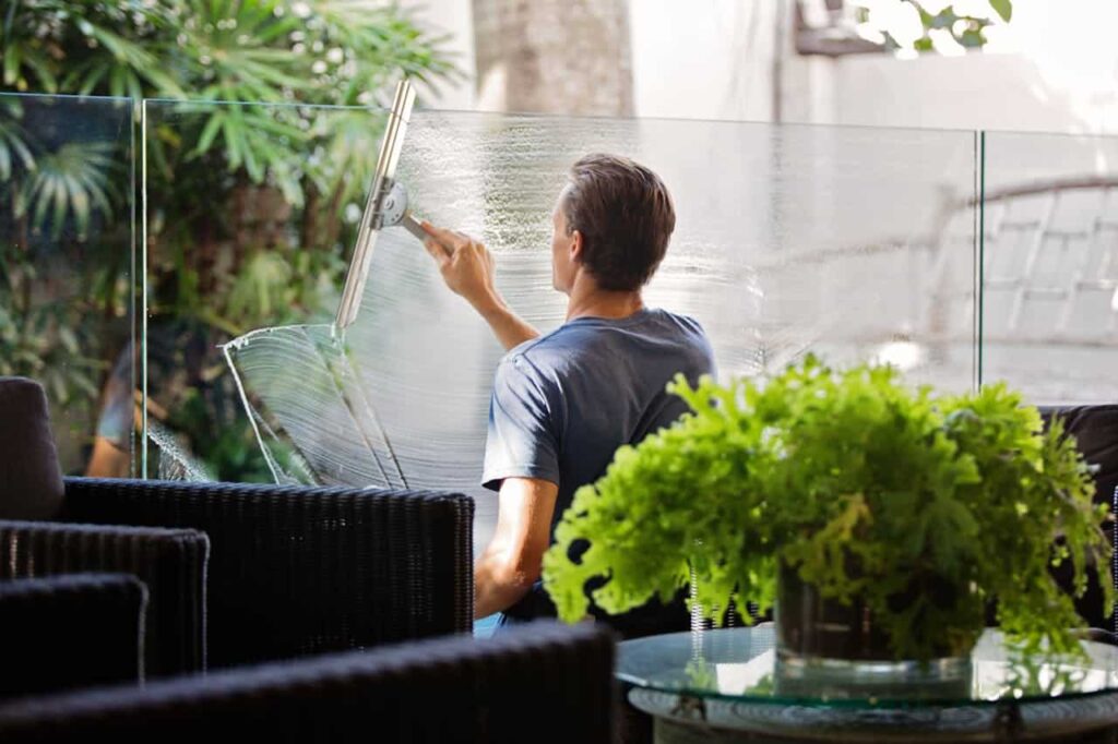 Window cleaner spraying and cleaning the inside of a window